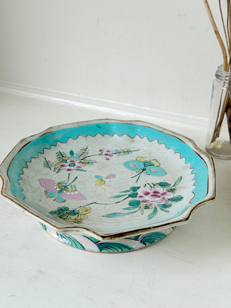 Antique ceramic footed dish with turquoise floral and bird design, photographed on a white surface.