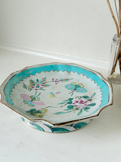 Antique ceramic footed dish with turquoise floral and bird design, photographed on a white surface.