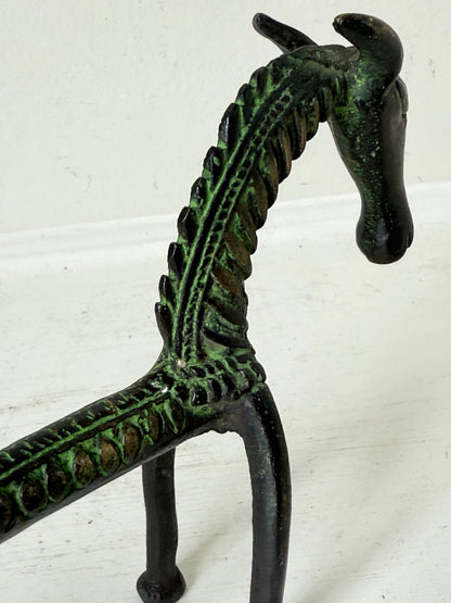 Vintage bronze horse sculpture with green patina, photographed on a white surface.