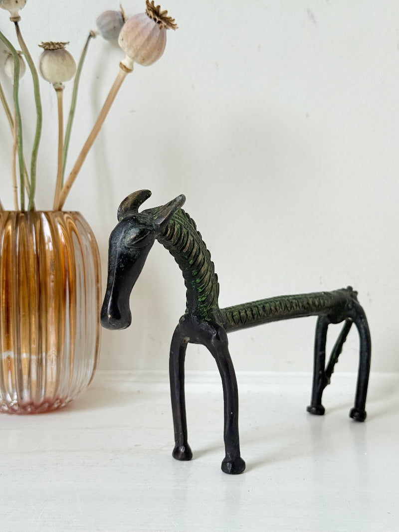 Vintage bronze horse sculpture with green patina, photographed on a white surface.