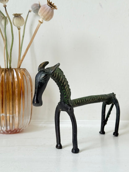 Vintage bronze horse sculpture with green patina, photographed on a white surface.