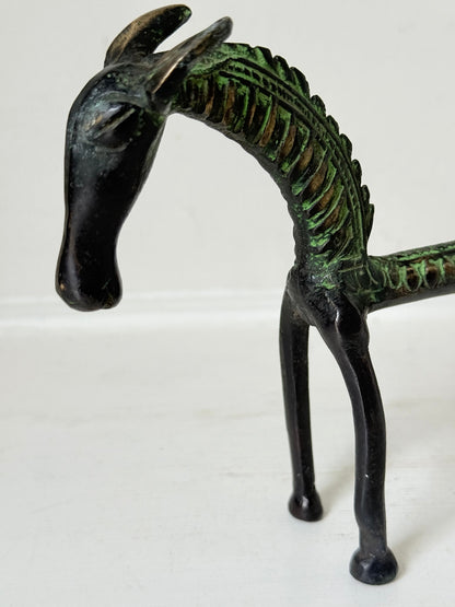 Vintage bronze horse sculpture with green patina, photographed on a white surface.