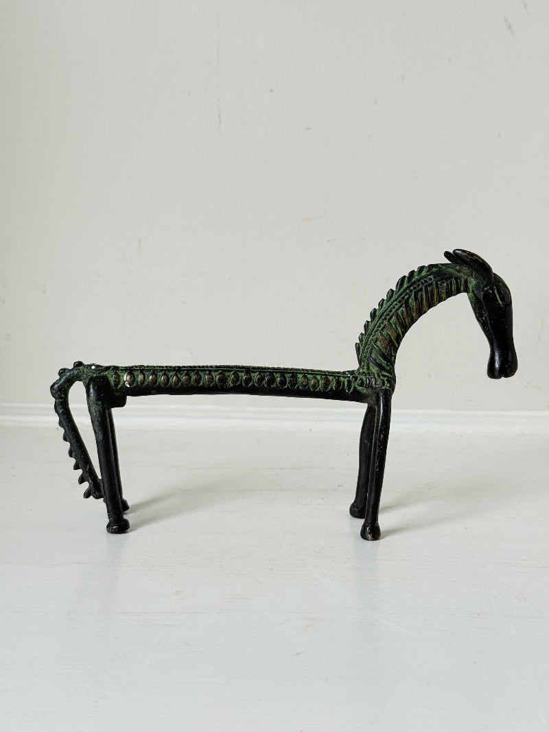 Vintage bronze horse sculpture with green patina, photographed on a white surface.