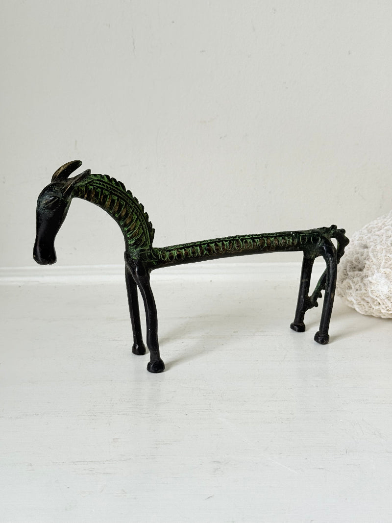 Vintage bronze horse sculpture with green patina, photographed on a white surface.
