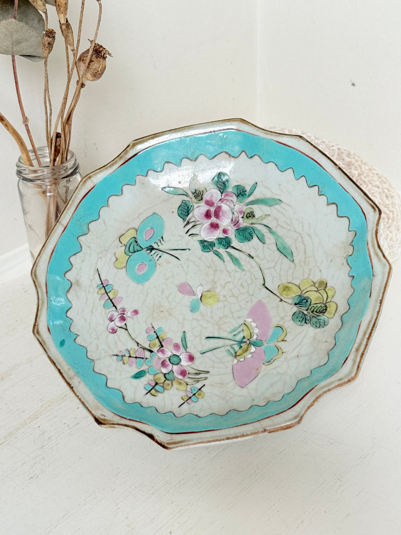 Antique ceramic footed dish with turquoise floral and bird design, photographed on a white surface.