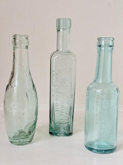 Trio of Antique Aqua Glass Bottles with Embossed Lettering