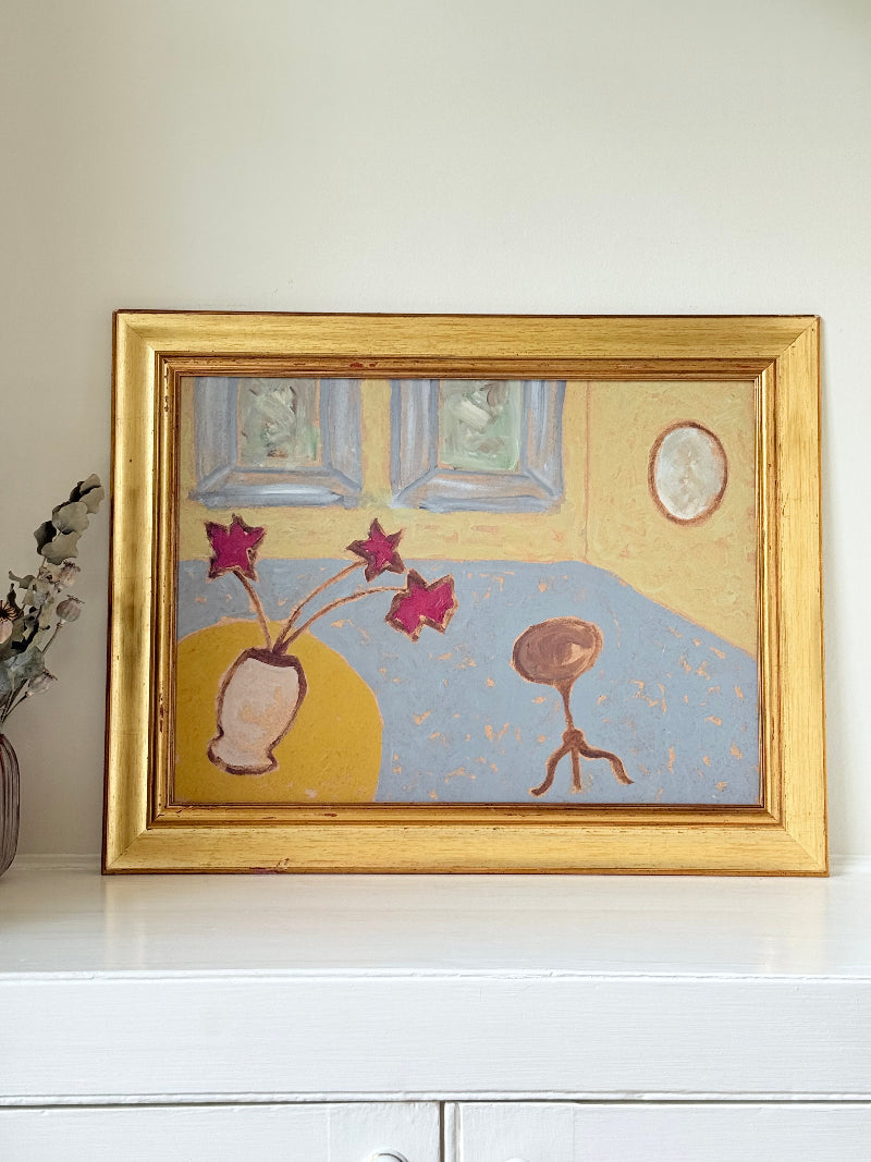 Naïve interior oil painting with red flowers in a vase, in golden frame, styled on a white dresser with neutral background
