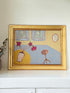 Naïve interior oil painting with red flowers in a vase, in golden frame, styled on a white dresser with neutral background