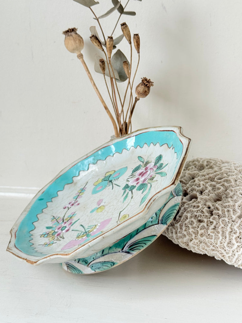 Antique ceramic footed dish with turquoise floral and bird design, photographed on a white surface.