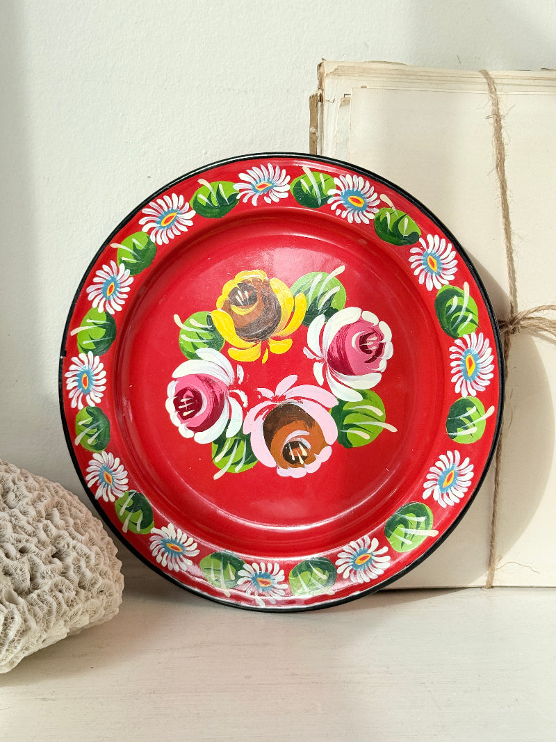 Rim of a vintage enamel plate painted with white daisies and green leaves