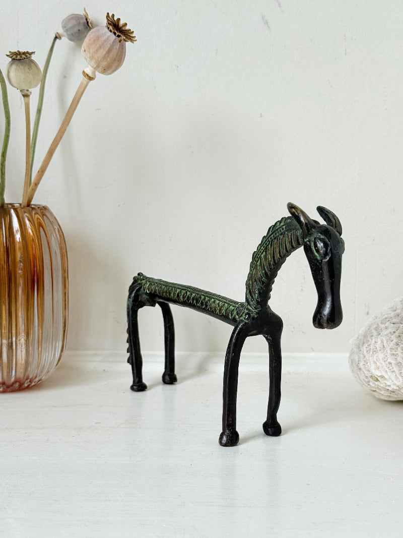 Vintage bronze horse sculpture with green patina, photographed on a white surface.