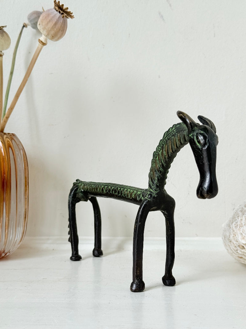 Vintage bronze horse sculpture with green patina, photographed on a white surface.