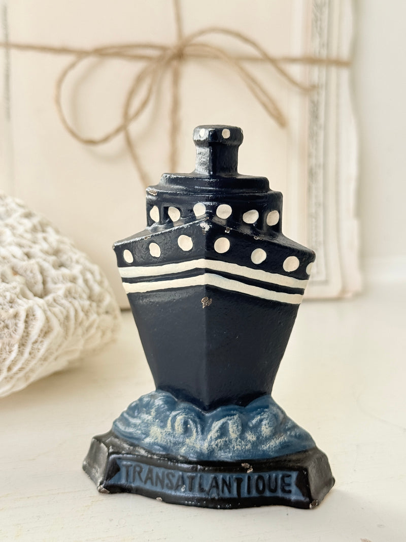 Vintage cast iron ocean liner doorstop in navy with white portholes and Transatlantique on the base