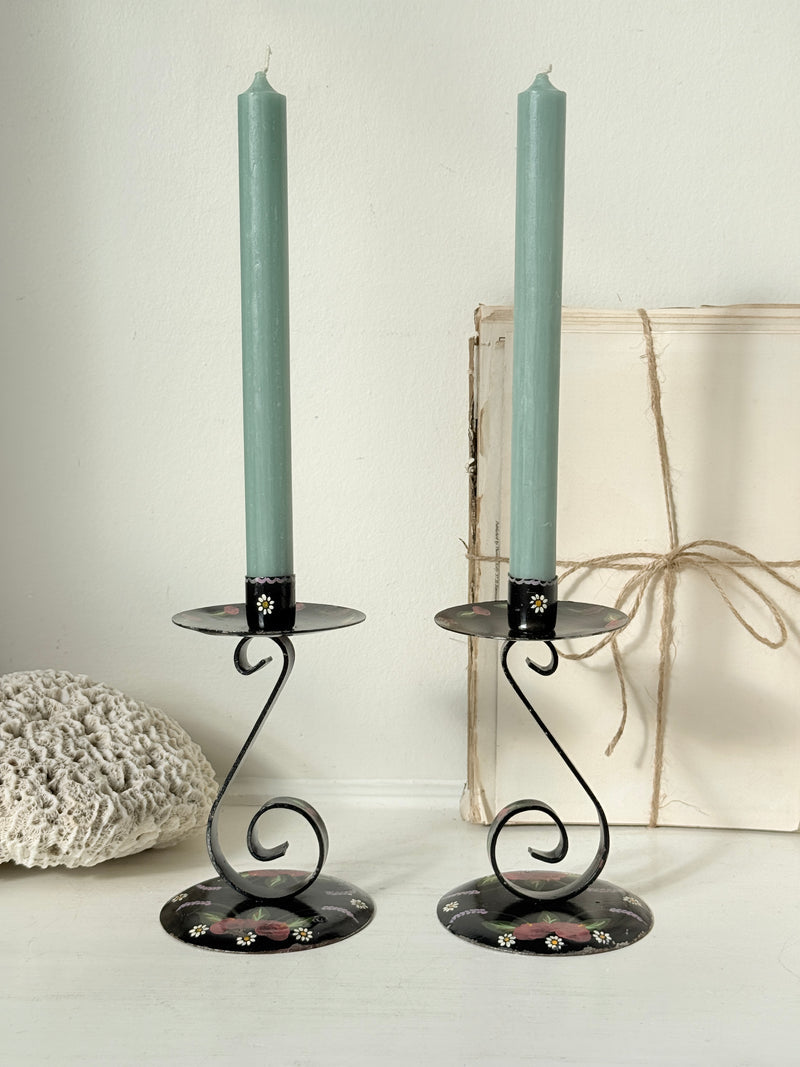 Vintage painted metal candlesticks holding sage green dinner candles