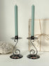 Vintage painted metal candlesticks holding sage green dinner candles